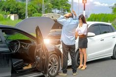 a man and woman standing next to a white car