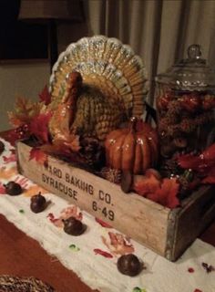 a table topped with a wooden box filled with turkeys and gourmet candies