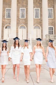 a group of women in graduation gowns posing for a photo