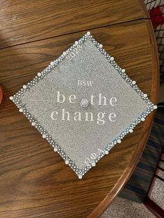 a table that has a sign on it with the words be the change written in white