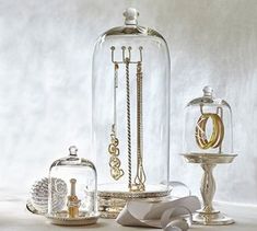 an assortment of jewelry is displayed under a clochet glass dome on a table