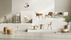 an assortment of chairs and stools on display in a room with concrete flooring