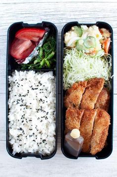 two black trays filled with rice, meat and veggies next to each other