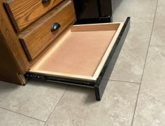 a drawer is open on the floor in front of a counter top with drawers underneath it