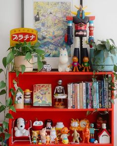 a red book shelf filled with lots of toys