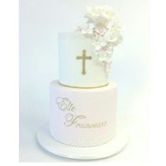 a white cake with flowers and a cross on top that says,'ele princess '