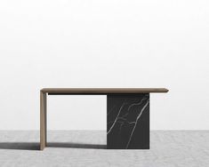 a black and white table sitting on top of a cement floor next to a wall