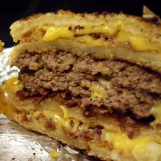 a cheeseburger is cut in half and sitting on a piece of wax paper