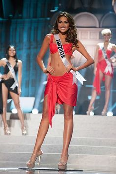 a beautiful young woman in a red dress on the runway