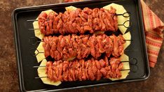 skewered meat and cheese on a baking sheet with napkins next to it