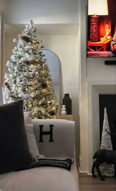 a living room decorated for christmas with a white tree in the corner and black accents