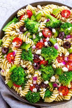 pasta salad with broccoli, tomatoes, olives and feta cheese in a bowl