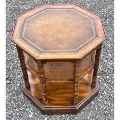 an octagonal wooden table sitting on top of gravel