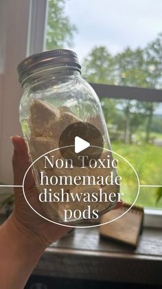 a person holding a jar with rocks in it and the words non - toxic homemade dishwasher pods