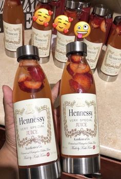 two bottles of honey with faces on them in front of some other bottles filled with liquid