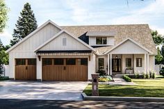 a large white house with two garages on the front and one story above it