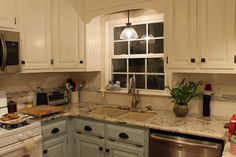 a kitchen with white cabinets and granite counter tops