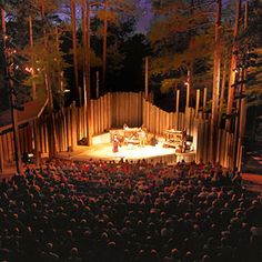 the american folklope theatre logo is lit up in front of an auditorium full of people