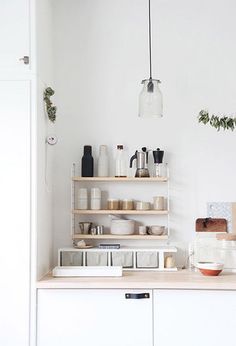 a kitchen with white walls and shelves filled with dishes