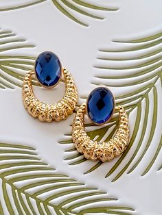 "Hello, welcome to Ken's Closet Today we have a beautiful pair of Textured Door Knocker Earrings, in gold. Adorned to each earring is an acrylic Saphire Blue crystal. The 2 sections are attached with a hinge. Earrings are a stud. The earring is about 2.5\" long." Star Sapphire, Hanging Earrings, Door Knockers, Black Crystals, Blue Crystals, Chandelier Earrings, Clear Crystal, Costume Jewelry, Blue Sapphire