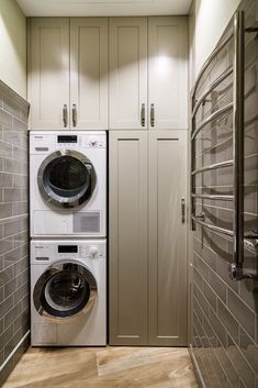 a washer and dryer in a small room with white cabinets on either side