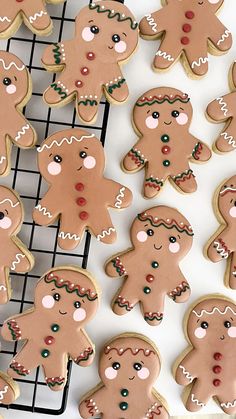 several decorated ginger cookies on a cooling rack