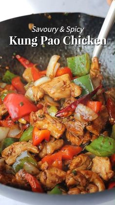 a wok filled with chicken, peppers and onions