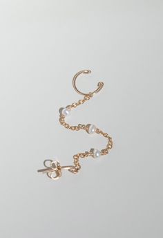 Get ready to add a touch of elegance to any outfit with our Delicate Pearl Cuff Earring! This unique earring features a delicate cuff design and a dangling pearl, making it the perfect accessory for any occasion. Upgrade your style game with a touch of sophistication and femininity. Details: Material: 14k Gold Filled Gemstone: Rice freshwater Pearl Chain Style: Cable Handcrafted Water resistant Hypoallergenic and Tarnish resistant Unique Earring, Cuff Design, Cuff Earring, Chain Earring, Pearl Cuff, Wrap Earrings, Jewelry Stand