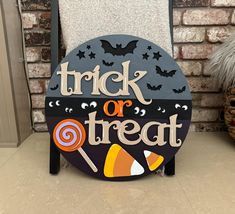 a trick or treat sign sitting on top of a chair next to a brick wall