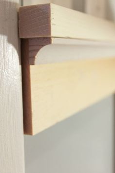 a close up view of the corner of a window frame with wood trim on it