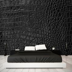 a black and white bedroom with a large bed in the center, next to a wall that has crocodile skin on it