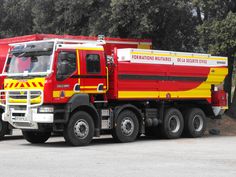 a red and yellow truck is parked on the street