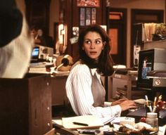 a woman sitting at a desk in front of a computer