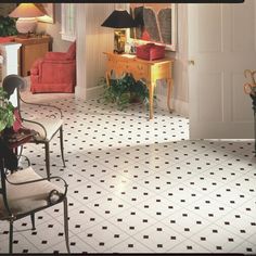 a living room filled with lots of furniture and decor on top of white tile flooring