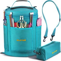 a blue bag with scissors, pens and other items in it next to a zippered pouch