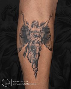 an angel tattoo on the leg of a woman