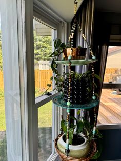 a three tiered plant stand in front of a window