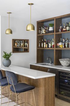 a kitchen with bar stools and shelves filled with bottles