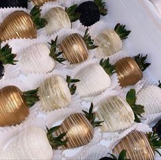 chocolate covered strawberries are lined up in white and gold foiled paper wrappers