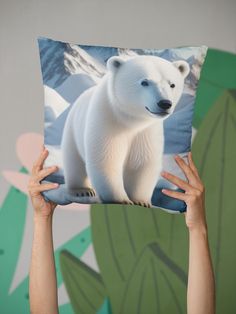 someone holding up a pillow with a polar bear on it