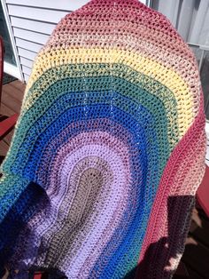 a crocheted rainbow blanket sitting on top of a chair