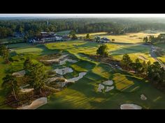 an aerial view of a golf course surrounded by trees