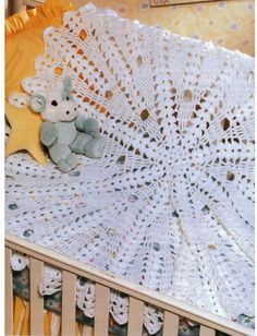 there is a crochet doily with a stuffed animal on it in the crib