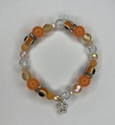 A orange evil eye bracelet with star charm Casual Bracelets With Star Charm As Gift, Casual Star Charm Bracelet As Gift, Casual Star Charm Bracelet Gift, Casual Orange Jewelry Gift, Casual Beaded Bracelets With Star Charm For Gift, Trendy Orange Bracelets For Gifts, Casual Orange Jewelry For Gifts, Trendy Orange Bracelets As Gift, Trendy Orange Bracelets As A Gift