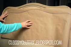 a woman is making a couch out of brown paper