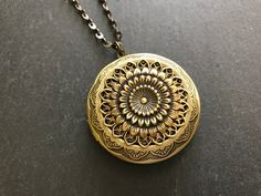 "Antique Bronze Floral Dahlia Locket... This is a gorgeous XL locket! I have attached a large antique brass filigree and dahlia brass stamping to the center of an extra large round ornate antique brass photo keepsake locket. The locket is suspended from an ornate dark antique brass non tarnish soldered chain that closes with a lobster claw clasp. It is absolutely beautiful and looks even better in person! Locket - 1.73\" in diameter (44mm in diameter) Interior photo area - 30-31mm approx. Chain Flower Keepsake, Woodland Jewelry, Memory Locket, Celestial Necklace, Gold Sun, Hippie Necklace, Animal Brooch, Photo Locket, Interior Photo