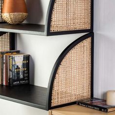 two bookshelves with wicker panels on each shelf and a candle next to them