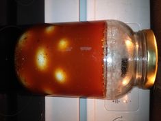 a jar filled with liquid sitting on top of a stove