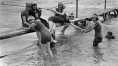 several people are in the water holding onto each other while they stand on a dock