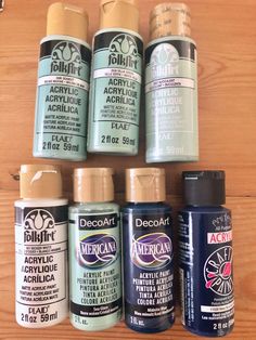 several different types of acrylic paint on a wooden surface